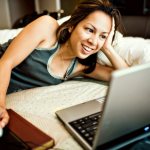 girl smiling looking at laptop
